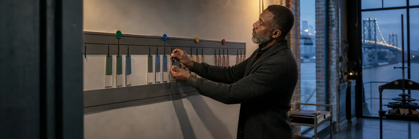 Harbor advisor arranges four seasonal markers along an unreadable wall calendar rail in a blue-hour waterfront studio.